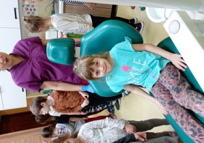 Dziewczynka pozuje do zdjęcia na fotelu dentystycznym